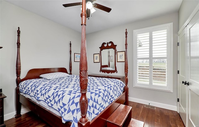 bedroom featuring multiple windows, baseboards, and wood finished floors