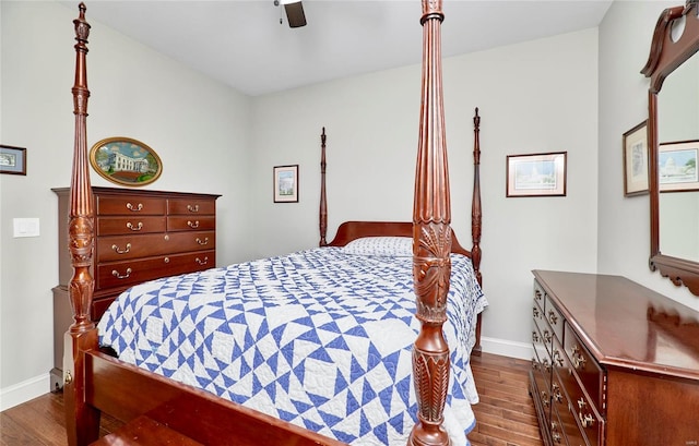 bedroom with a ceiling fan, dark wood-style floors, and baseboards