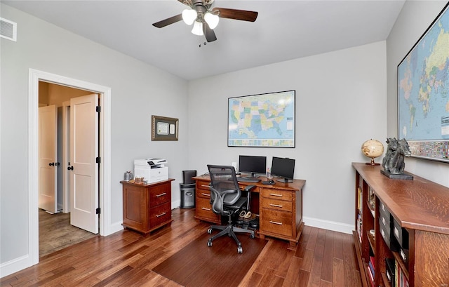 office featuring ceiling fan, visible vents, baseboards, and dark wood finished floors