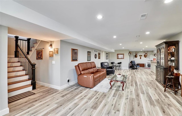 living room featuring stairway, recessed lighting, light wood-type flooring, and baseboards