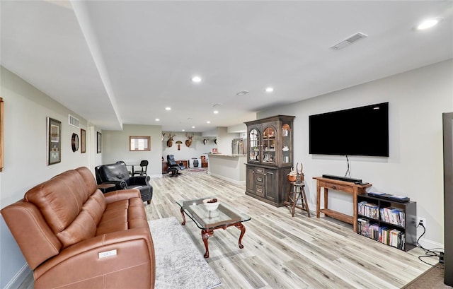 living room with light wood-type flooring, visible vents, and recessed lighting