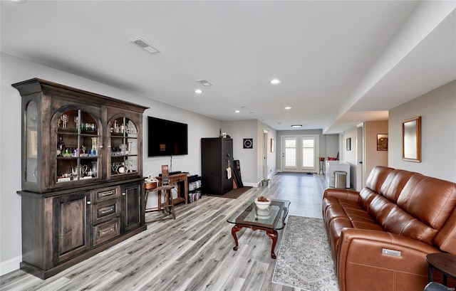 living room with recessed lighting, french doors, baseboards, and light wood-style flooring