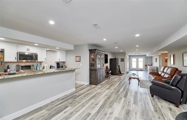 living area featuring visible vents, light wood finished floors, recessed lighting, a toaster, and baseboards