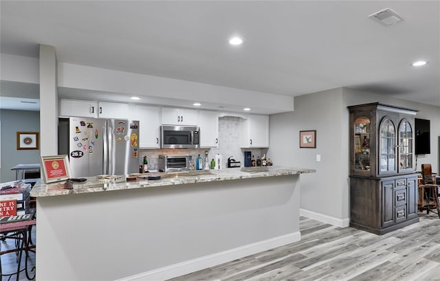 kitchen with tasteful backsplash, visible vents, appliances with stainless steel finishes, and white cabinetry