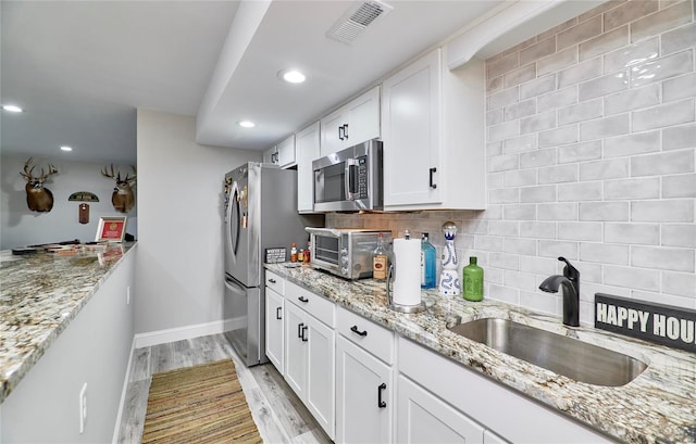 kitchen with visible vents, a sink, light wood-style floors, appliances with stainless steel finishes, and a toaster