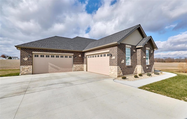 view of front of home with an attached garage, stone siding, driveway, and a shingled roof