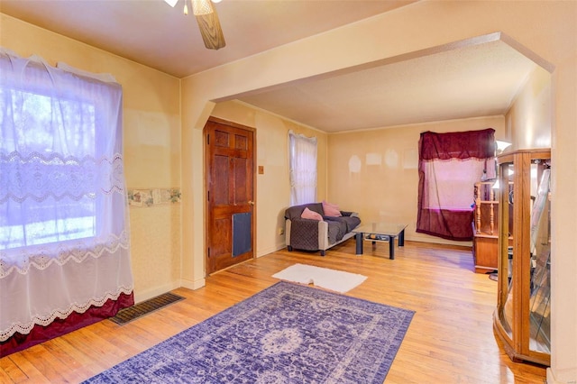 living area with wood-type flooring and ceiling fan