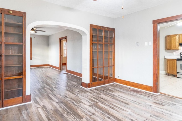 unfurnished room featuring ceiling fan, a textured ceiling, and light hardwood / wood-style flooring