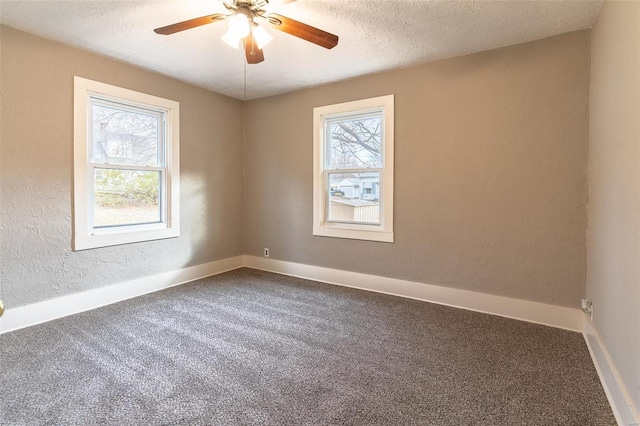 carpeted spare room with a textured ceiling, a wealth of natural light, and ceiling fan