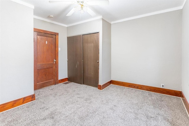 unfurnished bedroom with ceiling fan, light colored carpet, ornamental molding, and a closet