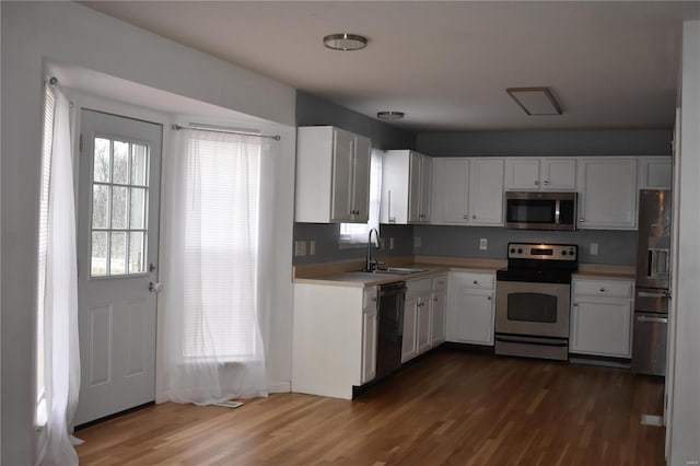 kitchen featuring white cabinets, sink, appliances with stainless steel finishes, and dark wood-type flooring