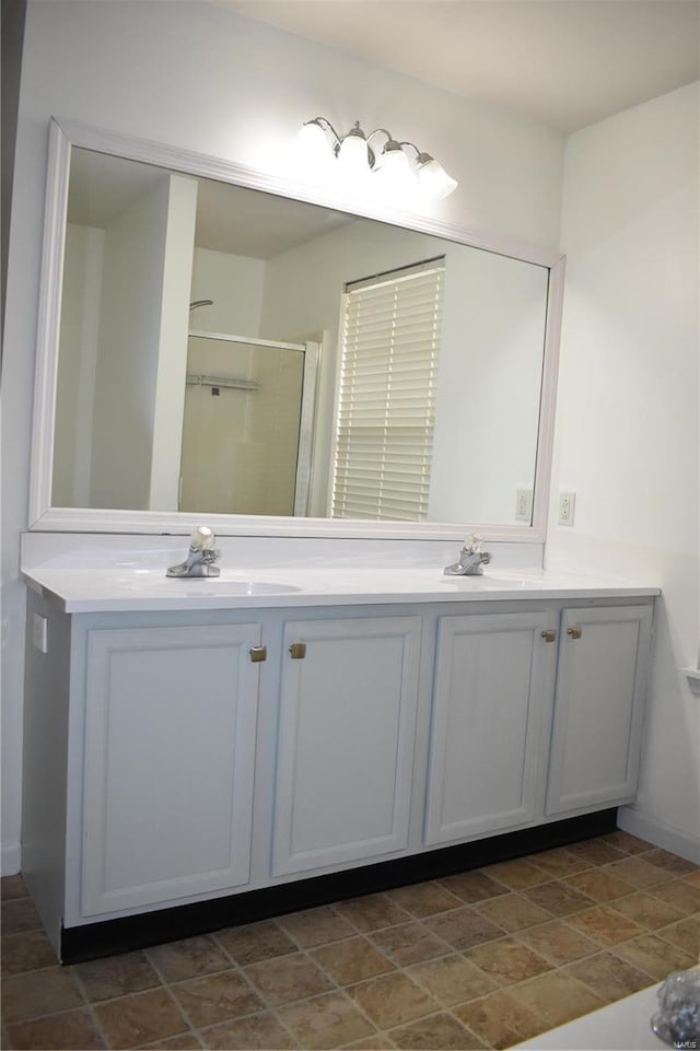 bathroom featuring a shower with door and vanity