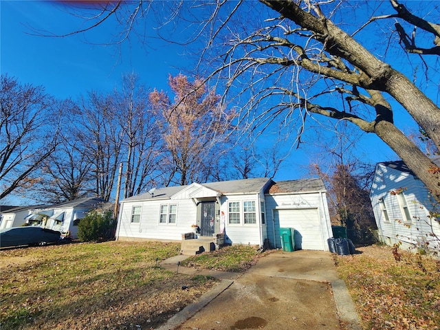 ranch-style home featuring driveway, an attached garage, and a front yard