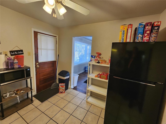 kitchen with light tile patterned floors, ceiling fan, and black appliances