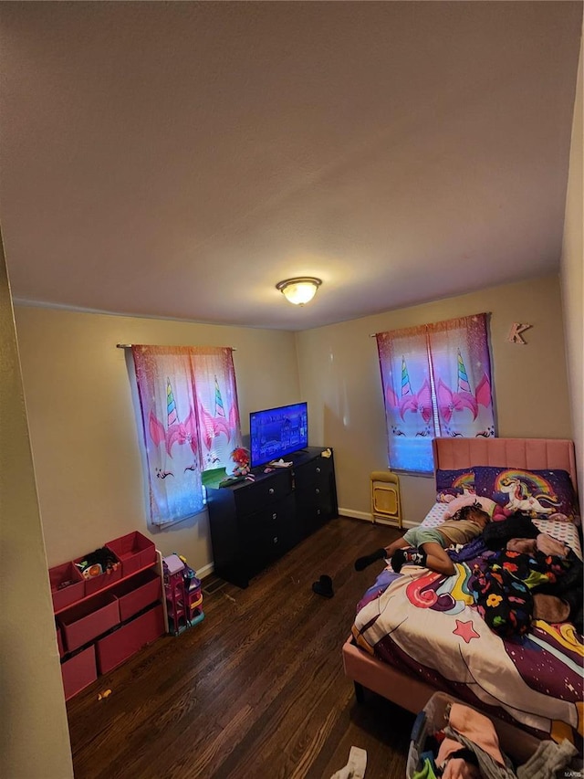 bedroom with dark wood-style flooring and baseboards