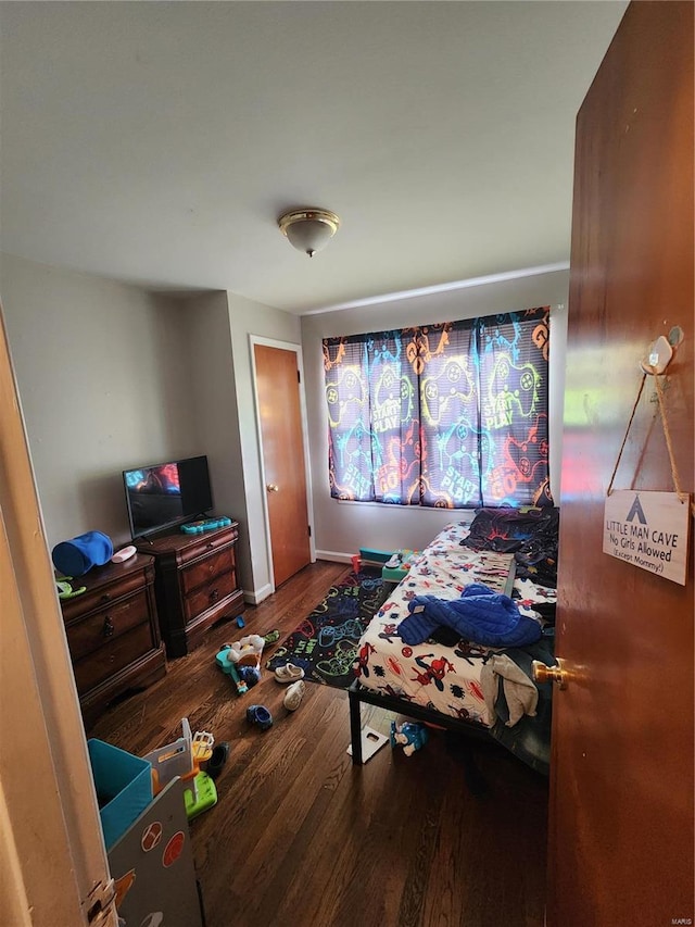 bedroom with baseboards and wood finished floors