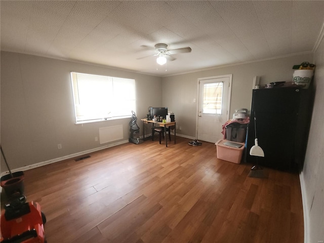 home office featuring wood-type flooring, a healthy amount of sunlight, ceiling fan, and ornamental molding