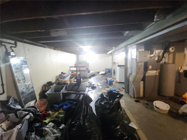 basement featuring water heater and washer / dryer