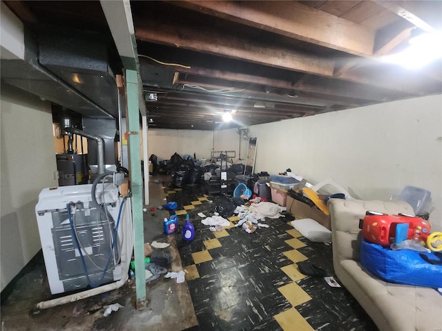 unfinished basement with water heater and dark floors