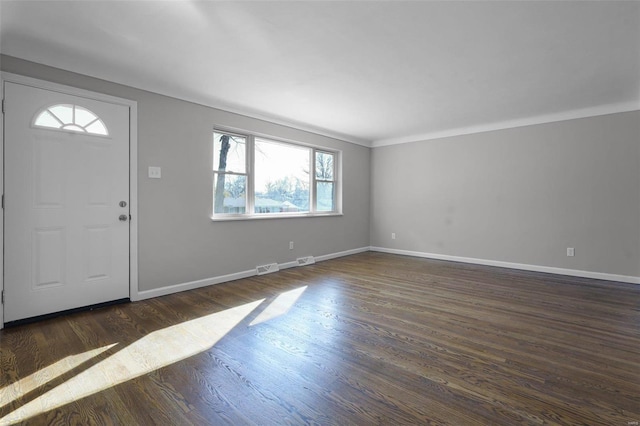 entryway with plenty of natural light, dark wood-type flooring, and ornamental molding