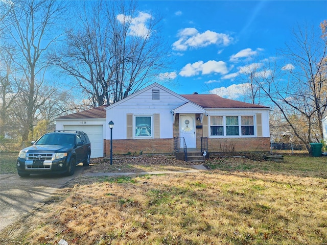 ranch-style home with a garage, brick siding, and a front lawn