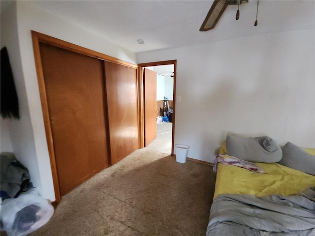 carpeted bedroom with ceiling fan and a closet