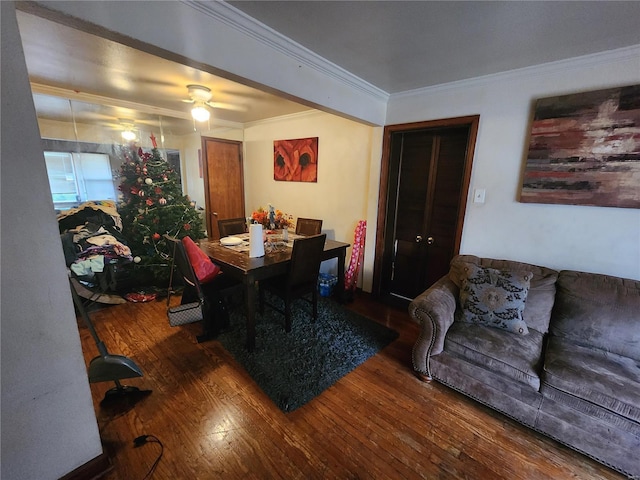 dining area with a ceiling fan, ornamental molding, and wood finished floors