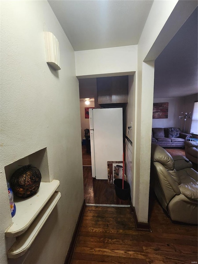 hallway featuring dark wood-style floors and baseboards