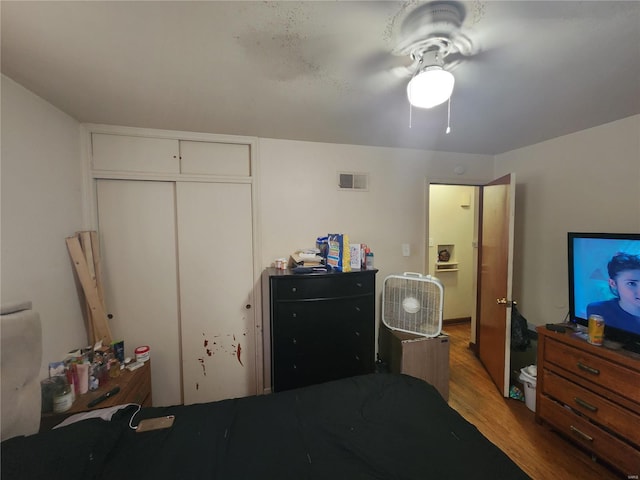 bedroom featuring ceiling fan, a closet, and light wood-type flooring