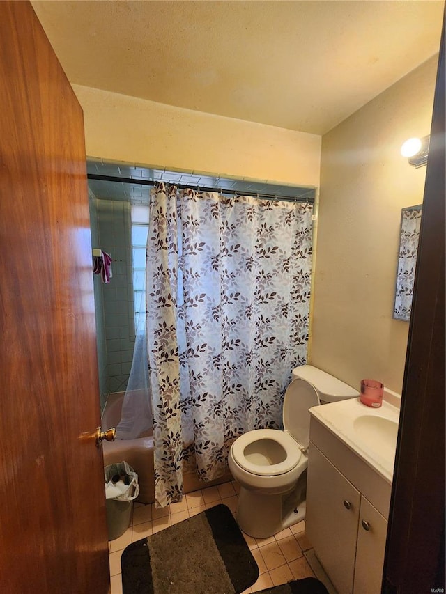 full bathroom with shower / bath combo with shower curtain, tile patterned floors, toilet, and vanity