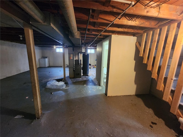 basement featuring heating unit, washer / clothes dryer, and water heater