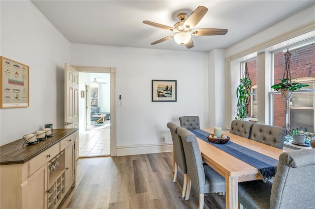 dining space with light wood-type flooring and ceiling fan