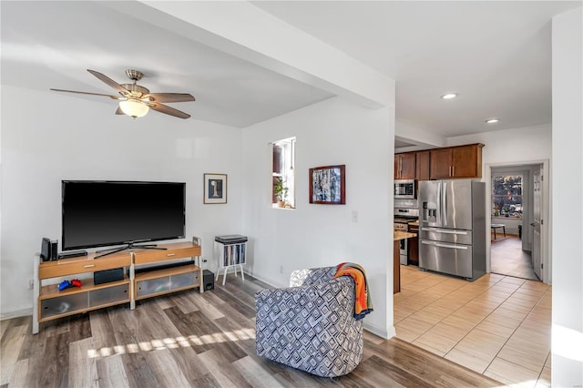 living room with light hardwood / wood-style flooring, plenty of natural light, and ceiling fan