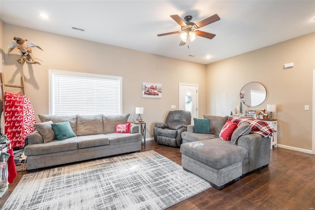 living room featuring dark hardwood / wood-style floors, ceiling fan, and a healthy amount of sunlight