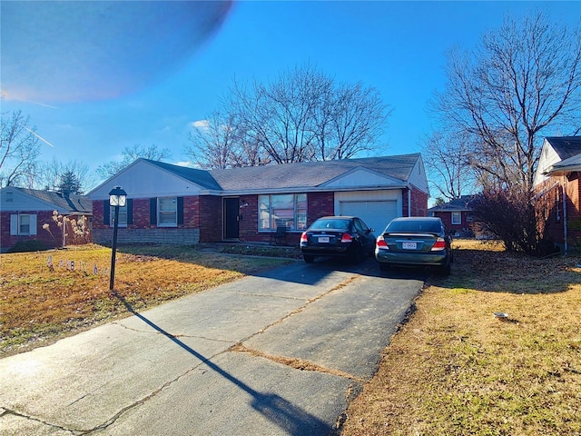 ranch-style house with a garage, aphalt driveway, a front yard, and brick siding