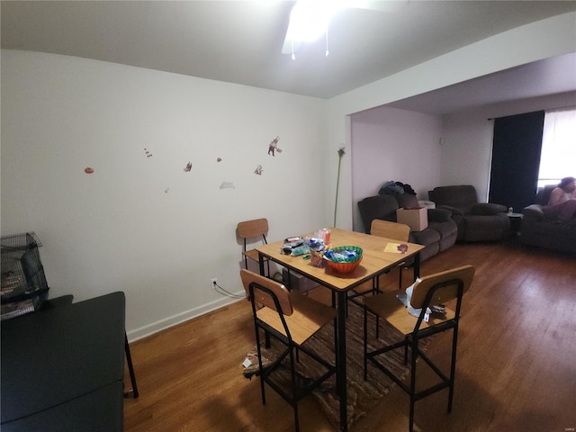 dining space featuring dark wood-style floors and baseboards