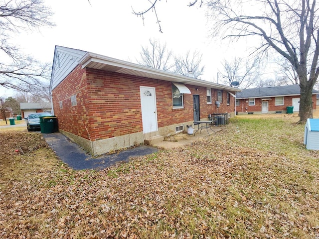 exterior space with central air condition unit and brick siding