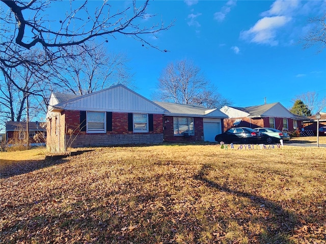 ranch-style house featuring a garage, brick siding, and a front yard