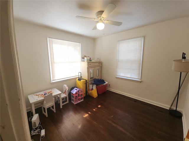 rec room with ceiling fan, baseboards, and dark wood-style flooring