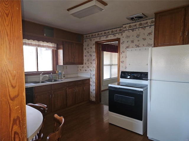 kitchen featuring sink, dark wood-type flooring, and white appliances