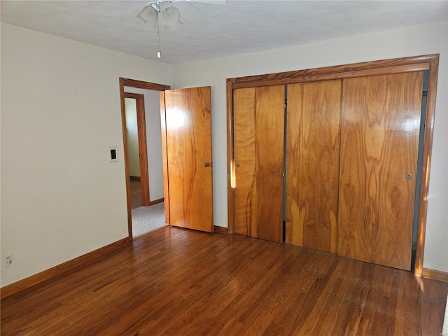 unfurnished bedroom featuring a closet, ceiling fan, and dark hardwood / wood-style flooring