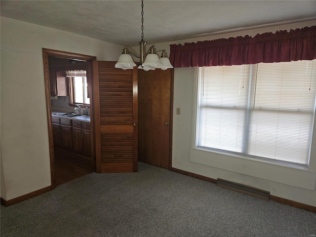 unfurnished dining area with dark colored carpet, a healthy amount of sunlight, and sink