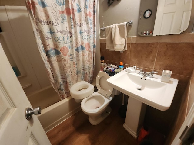 bathroom featuring shower / bath combination with curtain, tile walls, toilet, and wood finished floors