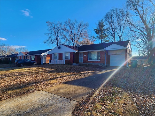 single story home featuring a garage, driveway, and brick siding