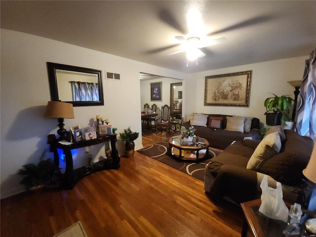 living room featuring ceiling fan, visible vents, and wood finished floors