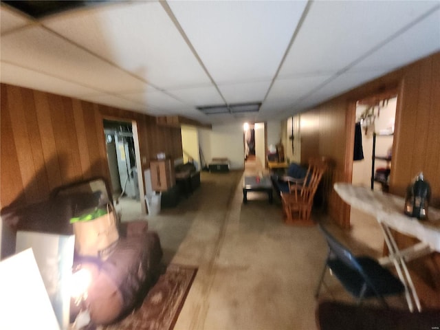 living room with wood walls and a drop ceiling