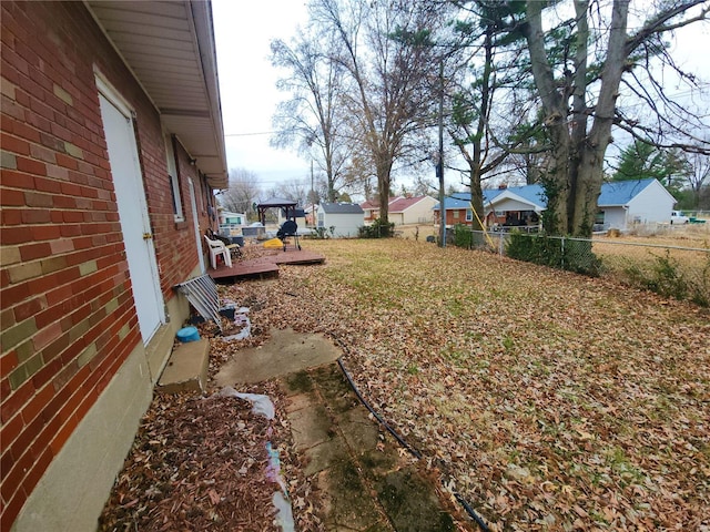 view of yard with a residential view, fence, and a wooden deck