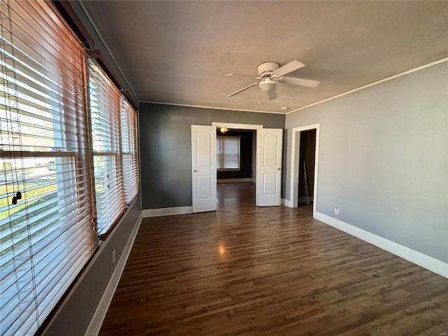 unfurnished room with dark hardwood / wood-style floors, ceiling fan, and crown molding