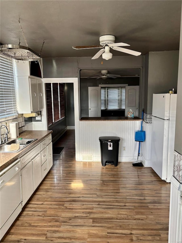 kitchen with white cabinetry, hardwood / wood-style floors, white appliances, and sink