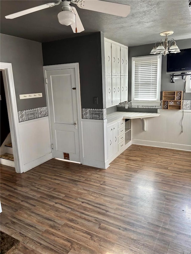 kitchen featuring a textured ceiling, white cabinetry, and dark hardwood / wood-style floors